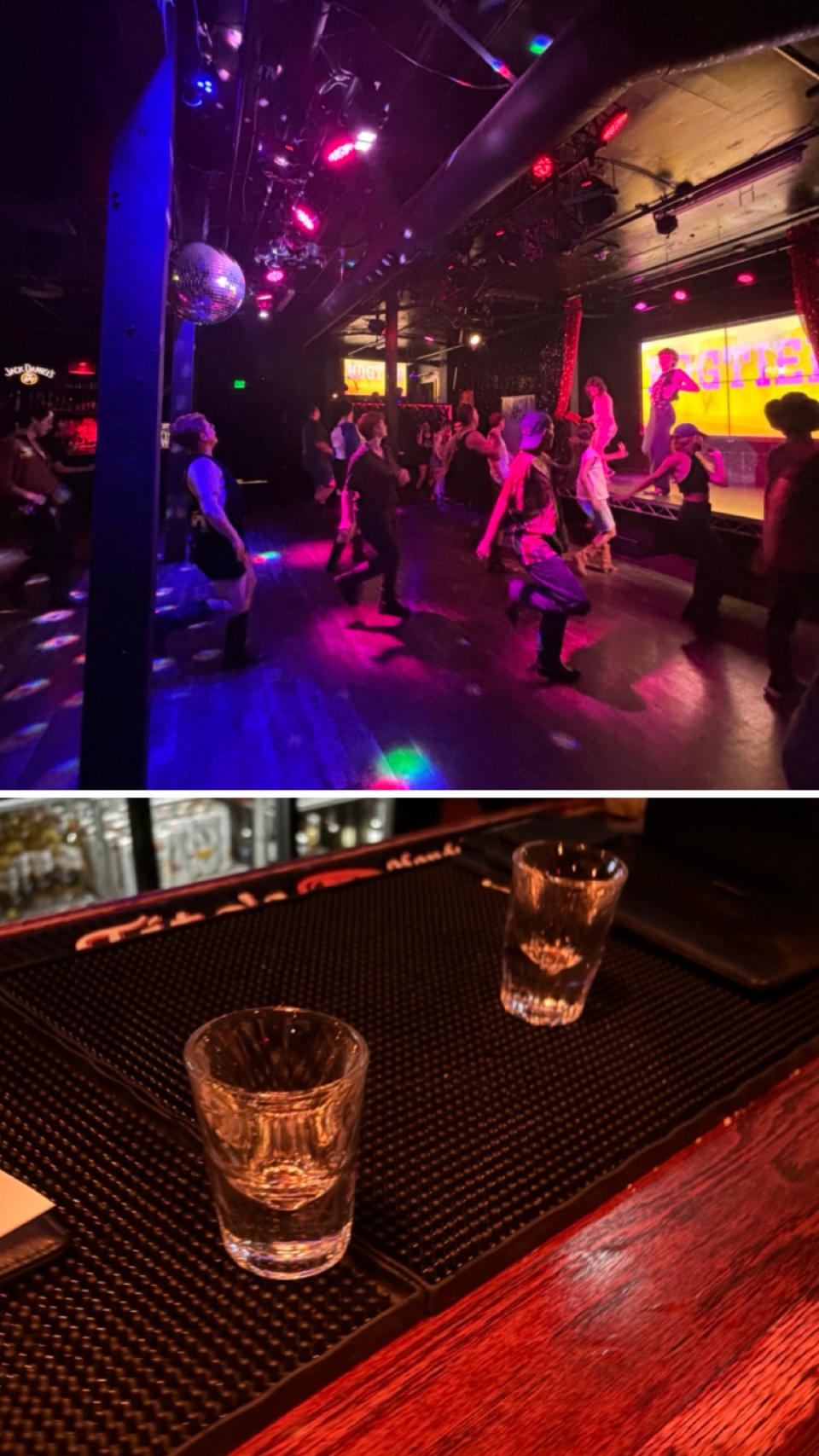 People dancing under bright lights in a nightclub, disco ball overhead; two empty shot glasses on a bar counter