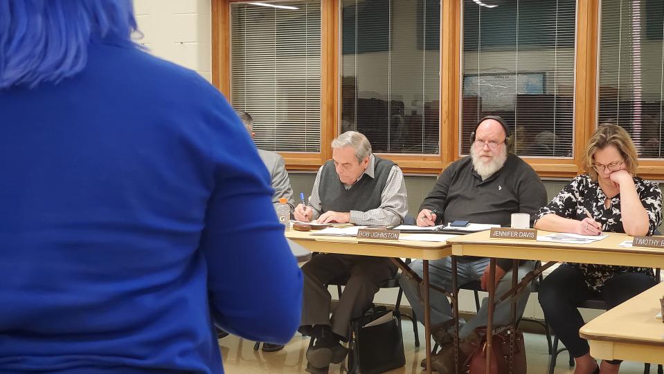 Penncrest School Board President Luigi DeFrancesco, Bob Johnston and Jennifer Davis listen as C.J. Rose, left, of Hayfield Township speaks against a proposed book ban at the board's work session on Jan. 9, 2023, at Saegertown Elementary School.