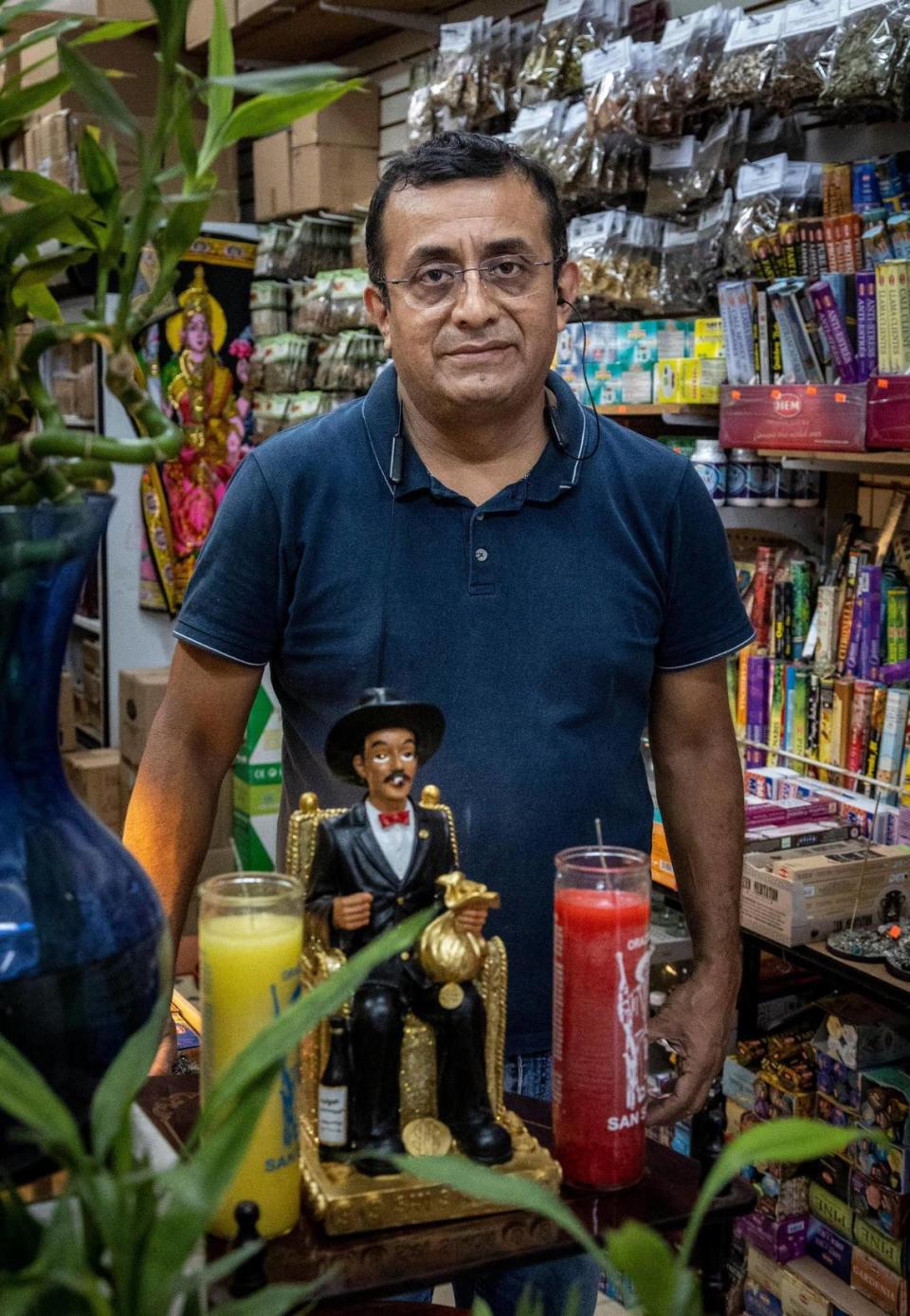 José Zevallos posa junto a una imagen de San Simón en Variedades Store M&N.