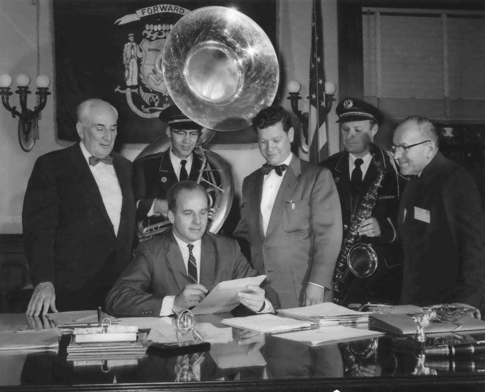 Gov. Gaylord Nelson gets musical backup as he signs into law the bill making "On, Wisconsin" the state's official song on July 7, 1959, in Madison.
