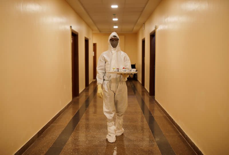 FILE PHOTO: A medical worker carries a tray with tea for the patients suffering from the coronavirus disease (COVID-19), at a hospital in Noida