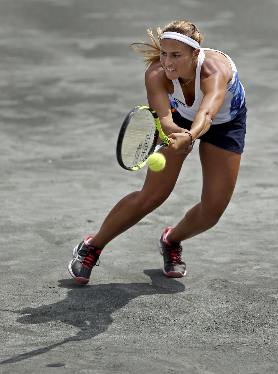 La puertorriqueña Mónica Puig intenta devolver un tiro ante la checa Katerina Siniakova en el torneo de la WTA en Charleston, Carolina del Sur. (Grace Beahm/The Post And Courier via AP)