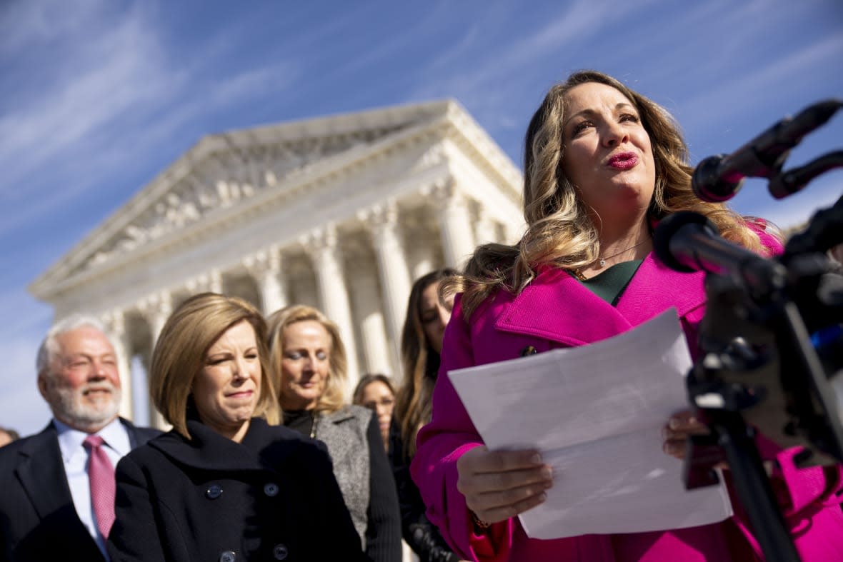 FILE – Lorie Smith, a Christian graphic artist and website designer in Colorado, right, accompanied by her lawyer, Kristen Waggoner of the Alliance Defending Freedom, second from left, speaks outside the Supreme Court in Washington, Monday, Dec. 5, 2022, after her case was heard before the Supreme Court. (AP Photo/Andrew Harnik, File)