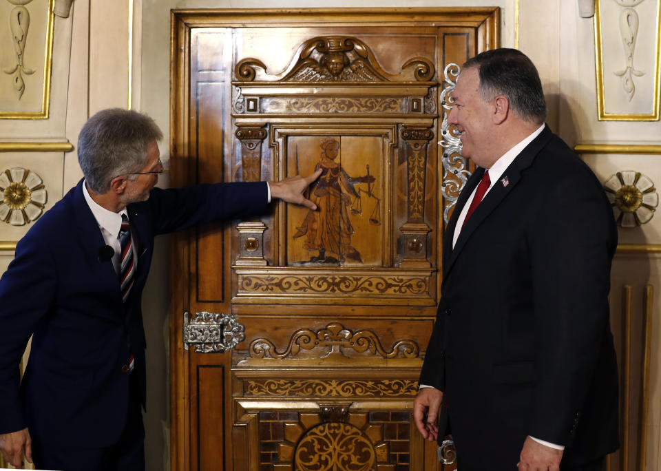 Milos Vystrcil, left, President of the senate, points to a door as he welcomes U.S. Secretary of State Mike Pompeo, right, in Prague, Czech Republic, Wednesday, Aug. 12, 2020. U.S. Secretary of State Mike Pompeo is in Czech Republic at the start of a four-nation tour of Europe. Slovenia, Austria and Poland are the other stations of the trip. (AP Photo/Petr David Josek, Pool)