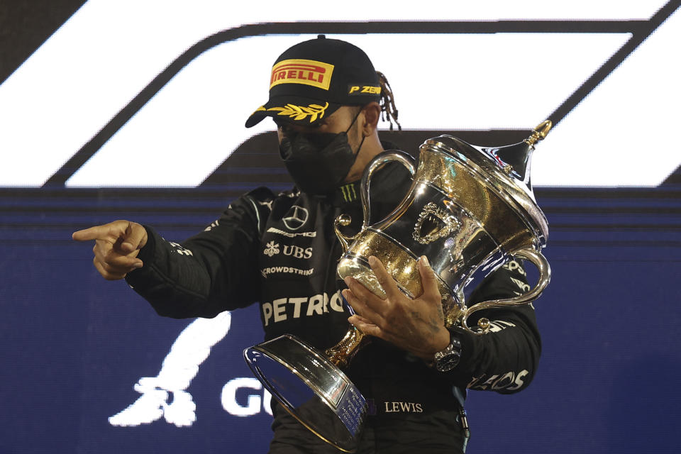 Mercedes driver Lewis Hamilton of Britain celebrates on the podium after winning the Bahrain Formula One Grand Prix at the Bahrain International Circuit in Sakhir, Bahrain, Sunday, March 28, 2021. (Lars Baron, Pool via AP)