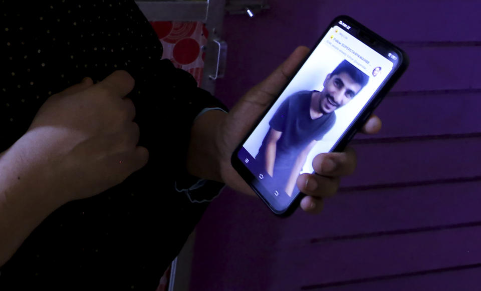 Nazima Shaikh, mother of Arbaz Mullah shows a smiling picture of Mullah from a video clip, at her home in Belagavi, India, Oct. 6, 2021. Arbaz Mullah was a Muslim man in love with a Hindu woman. But the romance so angered the woman’s family that — according to police — they hired members of a hard-line Hindu group to murder him. It's a grim illustration of the risks facing interfaith couples as Hindu nationalism surges in India. (AP Photo/Aijaz Rahi)