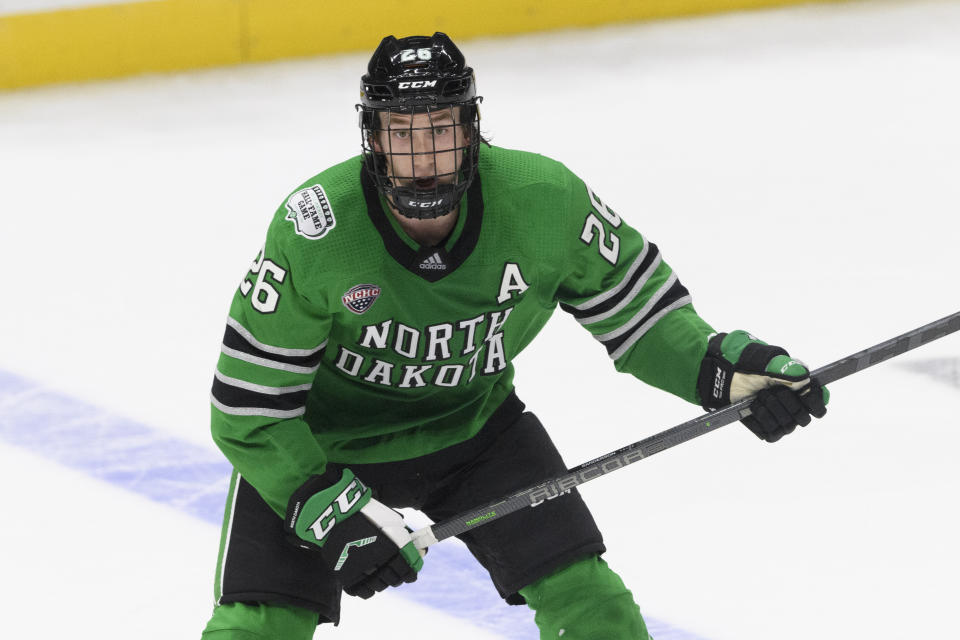 FILE - North Dakota defenseman Jake Sanderson plays against Penn State during an NCAA college hockey game on Saturday, Oct. 30, 2021, in Nashville, Tenn. USA Hockey and Hockey Canada are eyeing several college players to play at the Olympics after the NHL decided not to participate in Beijing. North Dakota’s Jake Sanderson has already agreed to play for the U.S. (AP Photo/John Amis, File)