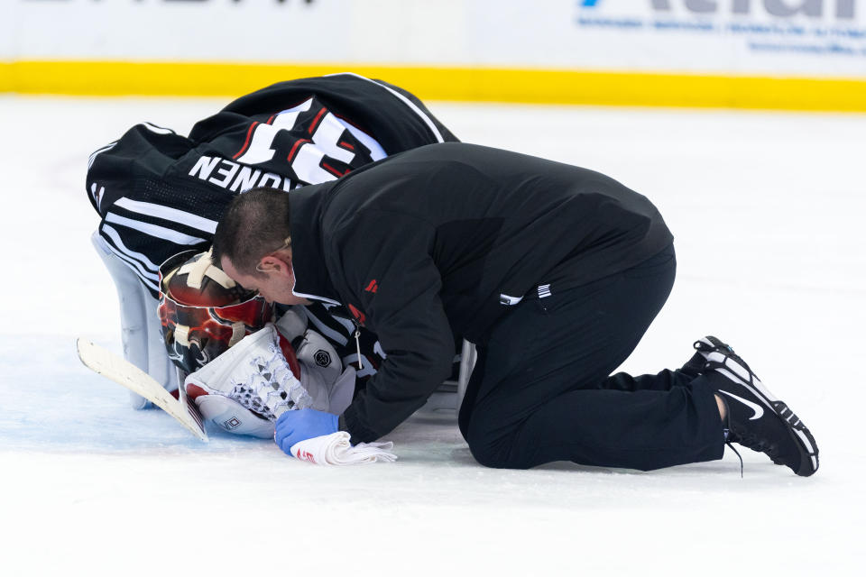 New Jersey Devils goaltender Kaapo Kahkonen, left, is tended to by a staff member, right, during the first period of an NHL hockey game against the Nashville Predators in Newark, N.J., Sunday, April 7, 2024. (AP Photo/Peter K. Afriyie)