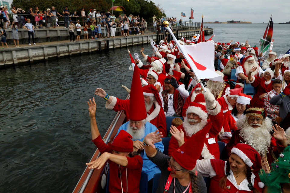 <p>People dressed as Santa Claus wave from a canal boat, as they take part in the World Santa Claus Congress, an annual event held every summer in Copenhagen, Denmark, July 23, 2018. (Photo: Andrew Kelly/Reuters) </p>