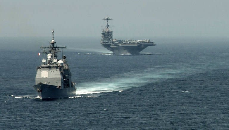 The guided-missile cruiser USS Gettysburg and aircraft carrier USS Harry S. Truman transit the Strait of Gibraltar on August 3, 2013 on their way to the Mediterranean Sea