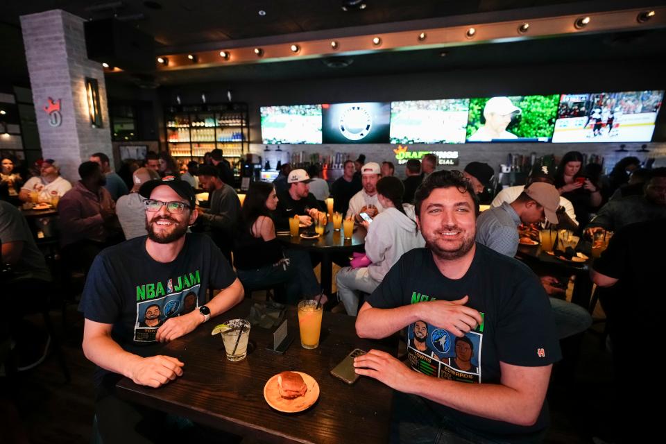 Alex Bucci, left, of Worthington and Richard Mettke of German Village watch the Cavs play the Celtics during the grand opening of DraftKings Sports & Social in the Short North.