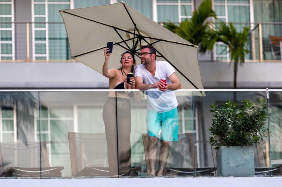 Un hombre y una mujer tomándose una selfie desde la terraza de Hotel Victor South Beach con vistas a Ocean Drive durante el fin de semana del Memorial Day en Miami Beach, la Florida, el domingo 28 de mayo de 2023.
