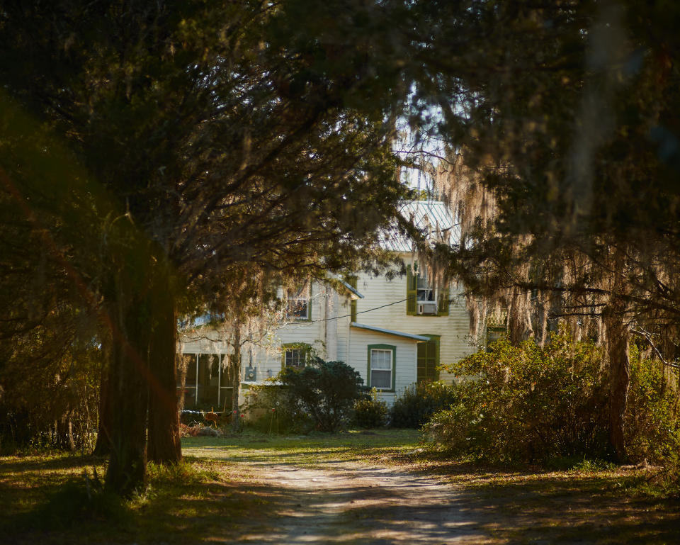 A view of a two-story white house from the road.