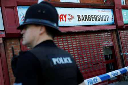 A police officer stands outside a barber's shop in Moss Side which was raided by officers in Manchester, Britain, May 26, 2017. REUTERS/Darren Staples