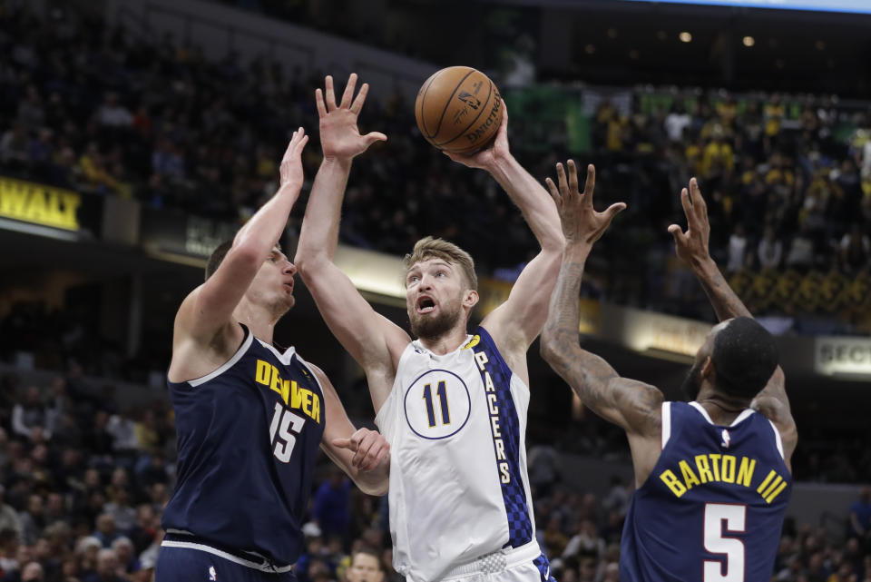 Indiana Pacers' Domantas Sabonis (11) goes up for a shot against Denver Nuggets' Nikola Jokic (15) and Will Barton (5) during the second half of an NBA basketball game Thursday, Jan. 2, 2020, in Indianapolis. Denver won 124-116. (AP Photo/Darron Cummings)