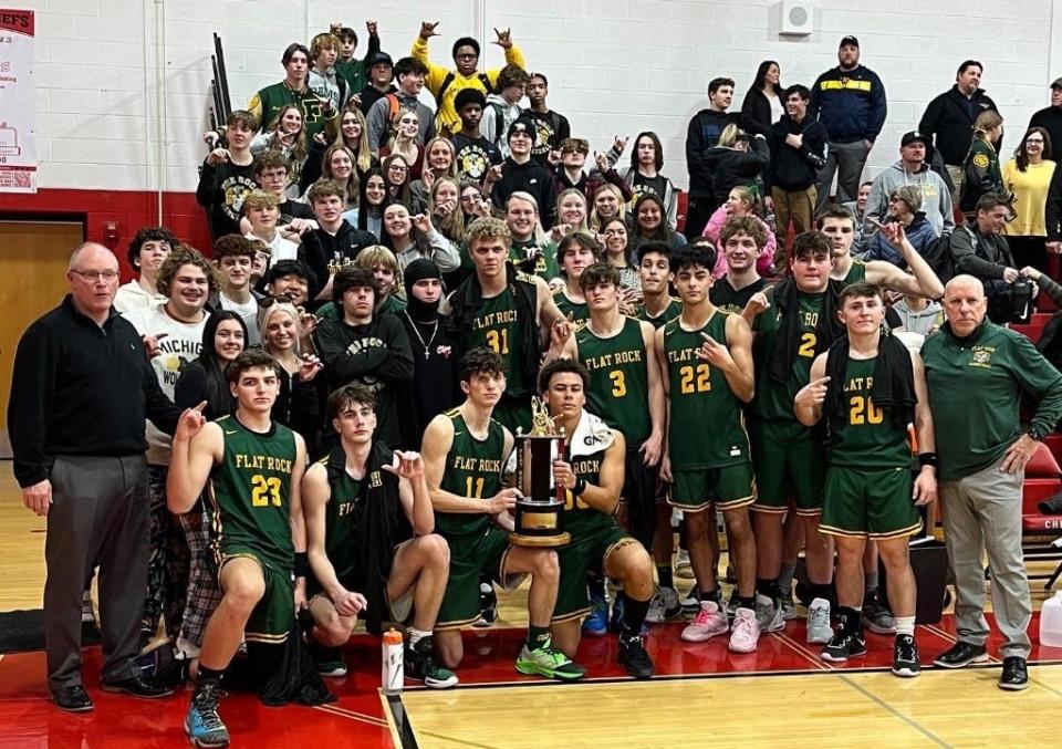 Flat Rock's boys basketball team celebrates Tuesday's 49-44 win over New Boston Huron with its student section.