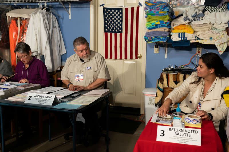 Poll workers Melanie Hernandez, Felipe Phil Casillas and Berenice Snyder chat inside the garage of the Hernandez residence, converted into a temporary polling station, on Super Tuesday in Bonita