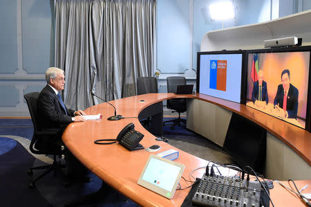 Chile's President Sebastian Pinera talks to Foreign Minister Roberto Ampuero during video conference after watching a live broadcast of the hearings at the World Court in The Hague in the Netherlands, at the government house in Santiago, Chile March 22, 2018. Alex Ibanez/Chilean Presidency/Handout via REUTERS