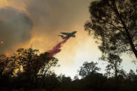 <p>A plane drops retardant while battling a wildfire near Oroville, Calif., on Saturday, July 8, 2017. The fast-moving wildfire in the Sierra Nevada foothills destroyed structures, including homes, and led to several minor injuries, fire officials said Saturday as blazes threatened homes around California during a heat wave. (AP Photo/Noah Berger) </p>