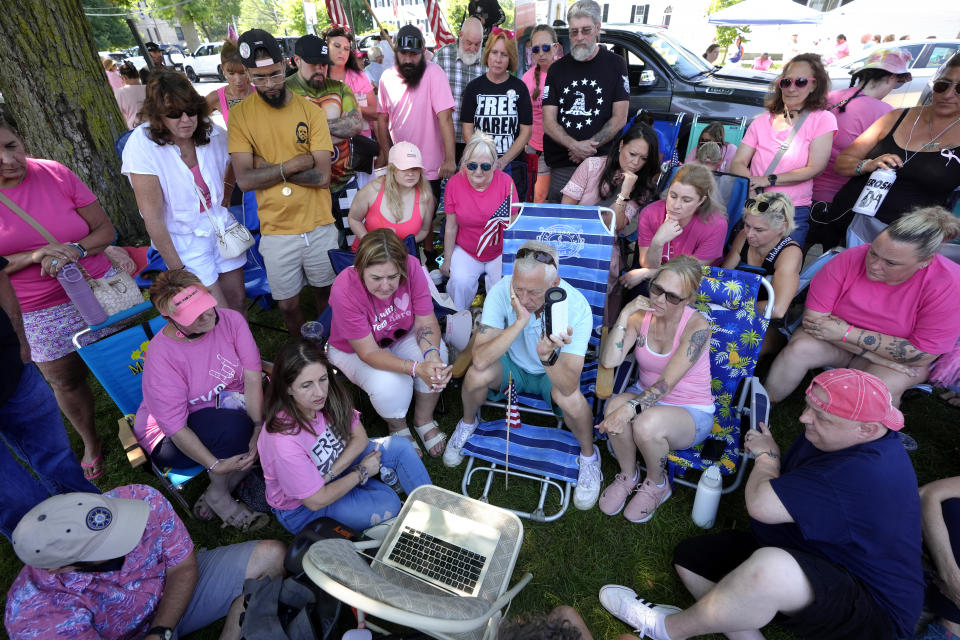 Supporters of Karen Read listen to proceedings from Read's trial from a laptop computer while gathered a block away from Norfolk Superior Court, Tuesday, June 25, 2024, in Dedham, Mass. Karen Read is on trial accused of killing her boyfriend Boston police Officer John O'Keefe, in 2022. (AP Photo/Steven Senne)