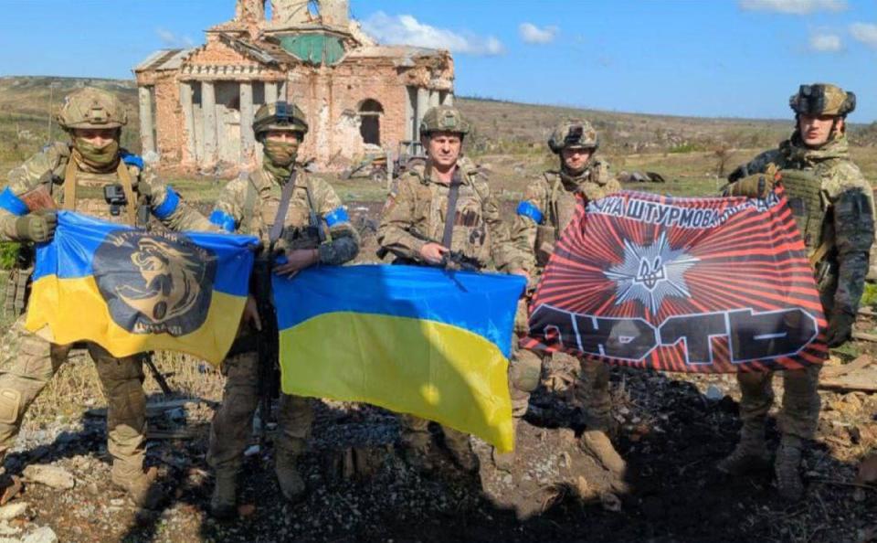 Ukrainian servicemen pose in front of a destroyed building in the village of Klyshchiivka (Ukrainian Presidential Chief of Staff Andriy Yermak/AFP via Getty Images)