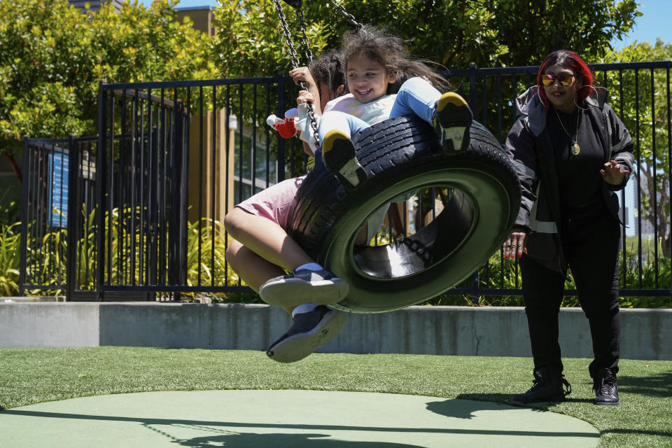 Teniah Tercero, right, pushes her two daughters Amairany, 8, left, and Valentina on a tire swing while spending time at a park Thursday, May 23, 2024, in San Francisco. (AP Photo/Godofredo A. Vásquez)