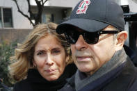 FILE - This March, 2019, file photo shows former Nissan Chairman Carlos Ghosn, right, and his wife Carole in Tokyo. Tokyo prosecutors issued an arrest warrant Tuesday, Jan. 7, 2020 for the wife of Nissan's former chairman, Carlos Ghosn, on suspicion of perjury. (Kyodo News via AP, File)