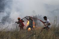 <p>Firefighters and volunteers try to extinguish the fire broke out at forested land in Penteli town of Athens, Greece on July 23, 2018. (Photo: Ayhan Mehmet/Anadolu Agency/Getty Images) </p>