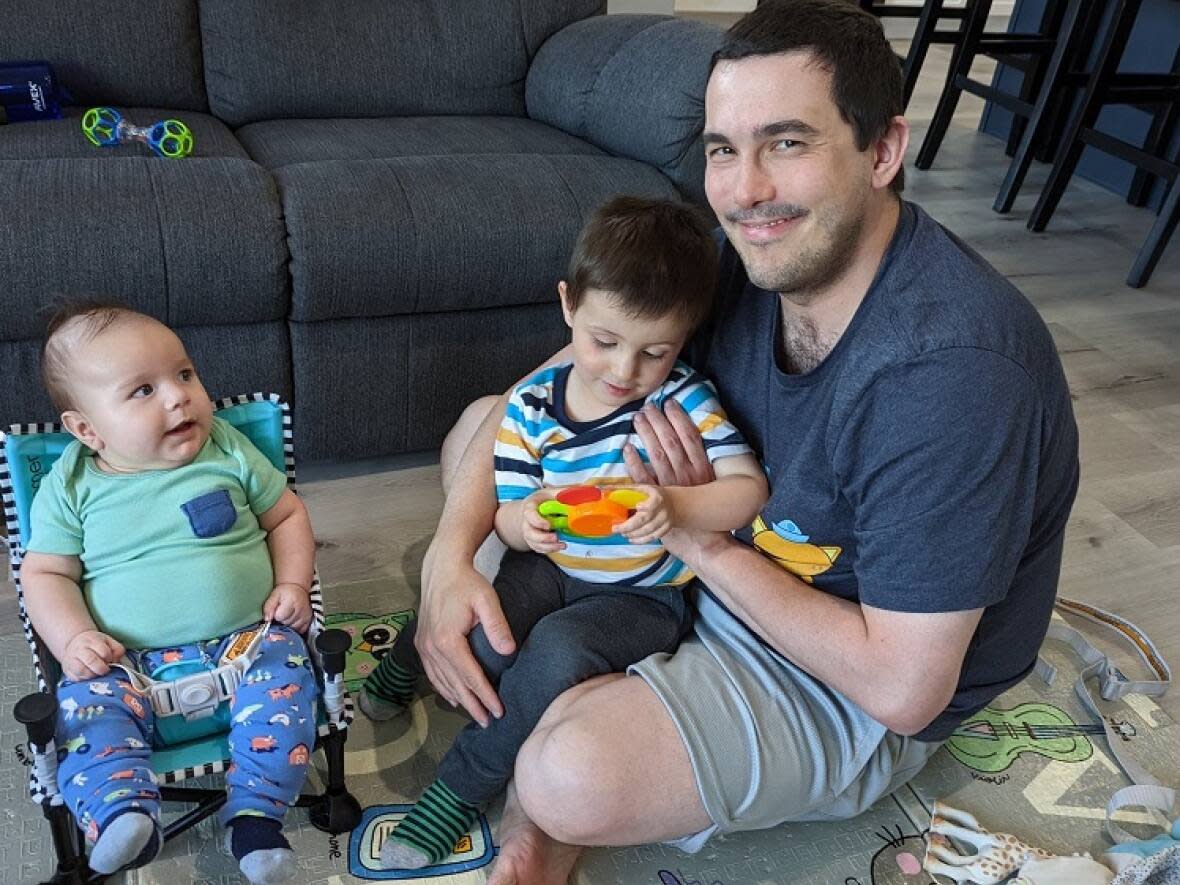 Saskatoon father Kyle Fisher plays with his two-and-a-half-year-old son Wilfred and his four-month-old son Stuart.  (Submitted by Kyle Fisher - image credit)