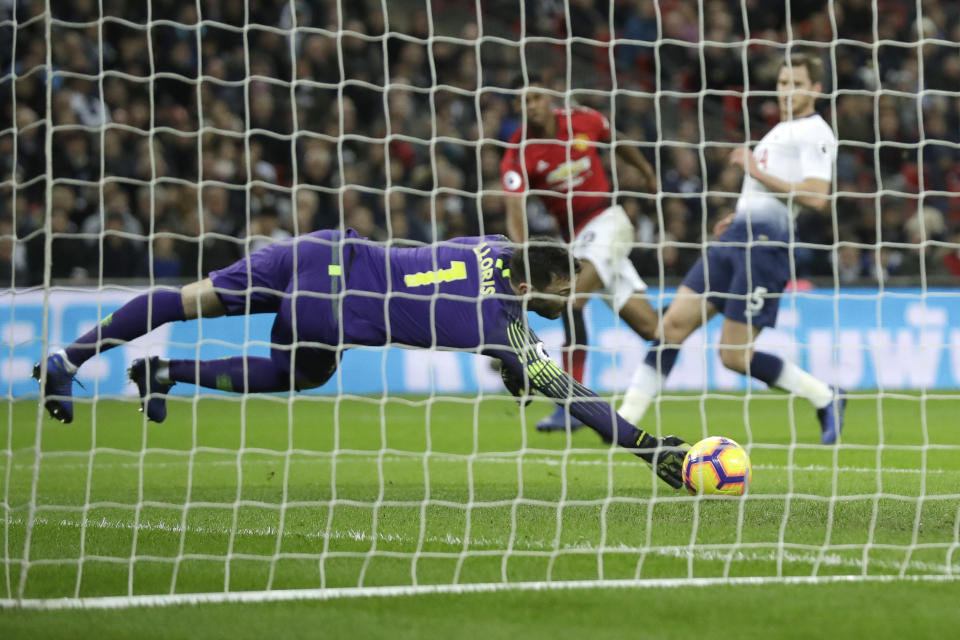 Tottenham goalkeeper Hugo Lloris fails to stop a shot on goal by Manchester United's Marcus Rashford, rear in red shirt, who scored his side's first goal during the English Premier League soccer match between Tottenham Hotspur and Manchester United at Wembley stadium in London, England, Sunday, Jan. 13, 2019. (AP Photo/Matt Dunham)