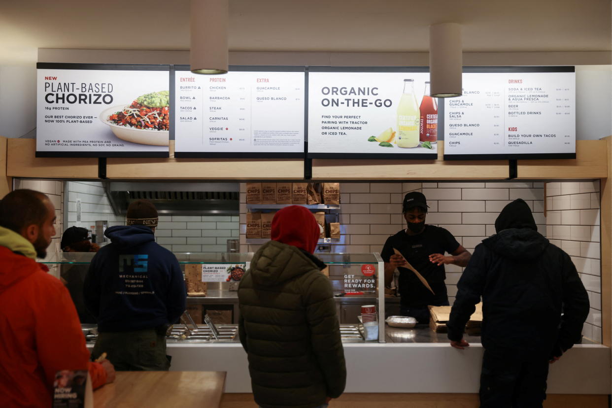 People are served in a Chipotle outlet in Manhattan, New York City, U.S., February 7, 2022. REUTERS/Andrew Kelly