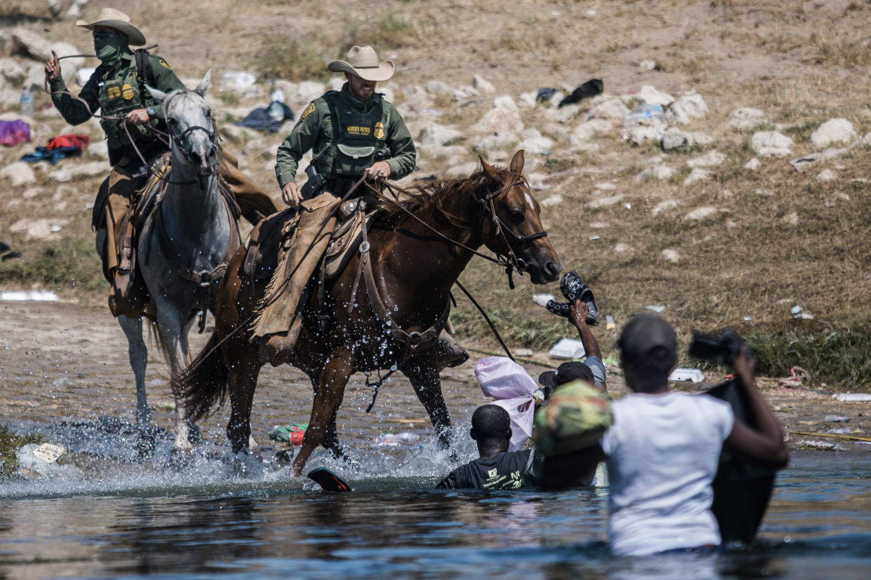 FILE - Mounted U.S. Border Patrol agents attempt to contain migrants as they cross the Rio Grande from Ciudad Acuña, Mexico, into Del Rio, Texas, Sept. 19, 2021. The administration began a massive expulsion of thousands of Haitians while allowing thousands of others to stay in the U.S. The uneven response, which at one point included Border Patrol agents on horseback appearing to use reins as whips to corral Haitian asylum seekers, sparked sharp criticism and underscored for many a failed border policy. (AP Photo/Felix Marquez, File)