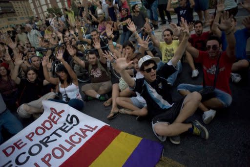 Thousands of Spanish "indignant" protesters rallied against austerity cuts Friday night before some of them clashed with police, who charged demonstrators with batons