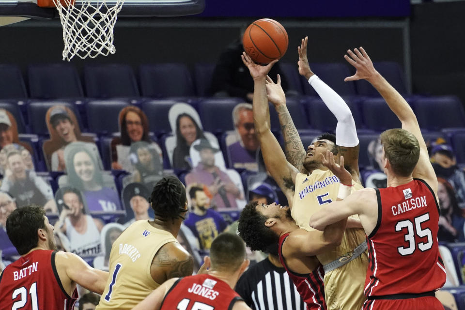 Washington forward Nate Roberts (5) puts up a shot between Utah center Branden Carlson (35) and forward Timmy Allen, third from right, during the second half of an NCAA college basketball game, Sunday, Jan. 24, 2021, in Seattle. Washington won 83-79. (AP Photo/Ted S. Warren)