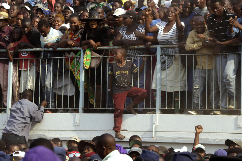 Zimbabweans look on at happening at the Rufaro Stadium in Harare, Thursday, Sept. 12, 2019 where former President Robert Mugabe lies in state for a public viewing. Mugabe, the founder leader, made his final journey back to the country Wednesday amid continuing controversy over where he will be buried. (AP Photo/Themba Hadebe)