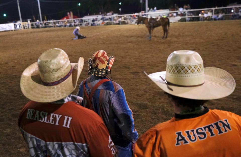 Rodeo bull fighters watch a contestant in steer roping at the Boley parade and rodeo on Memorial Day weekend on May 26.