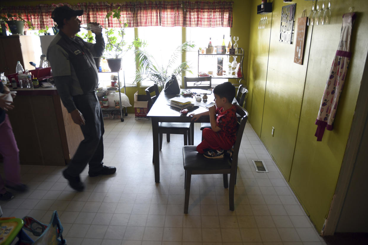 Anthony Johnson and his grandson, Lukas Lee Mora, 4, in their home in Las Vegas, N.M., on Tuesday, May, 3, 2022. Flames raced across more of New Mexico's pine-covered mountainsides Tuesday, charring more than 217 square miles (562 square kilometers) over the last several weeks. Johnson and his wife have packed up their valuables and are ready to leave the area if the fire tops the ridge behind their house. (AP Photo/Thomas Peipert)