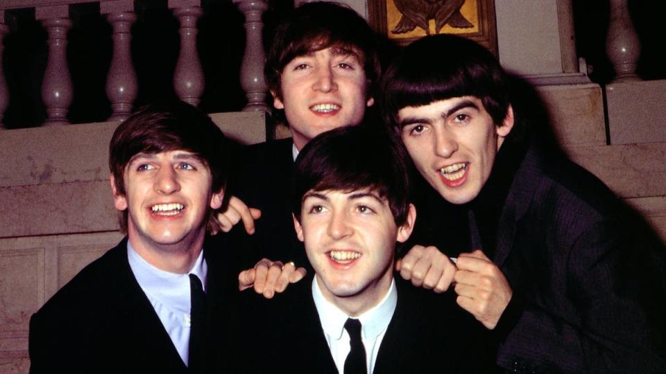 Boys smiling for a photo; greatest rock bands of all time