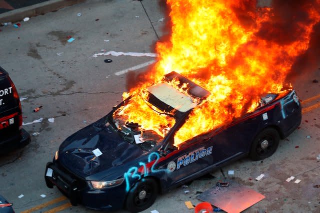 A police car burns after protesters marched to the Georgia State Capitol 