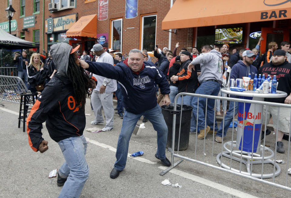 A protestor, left, fights with a bar patron outside of a bar near Oriole Park at Camden Yards after a rally for Freddie Gray, Saturday, April 25, 2015, in Baltimore. Gray died from spinal injuries about a week after he was arrested and transported in a police van. (AP Photo/Patrick Semansky)