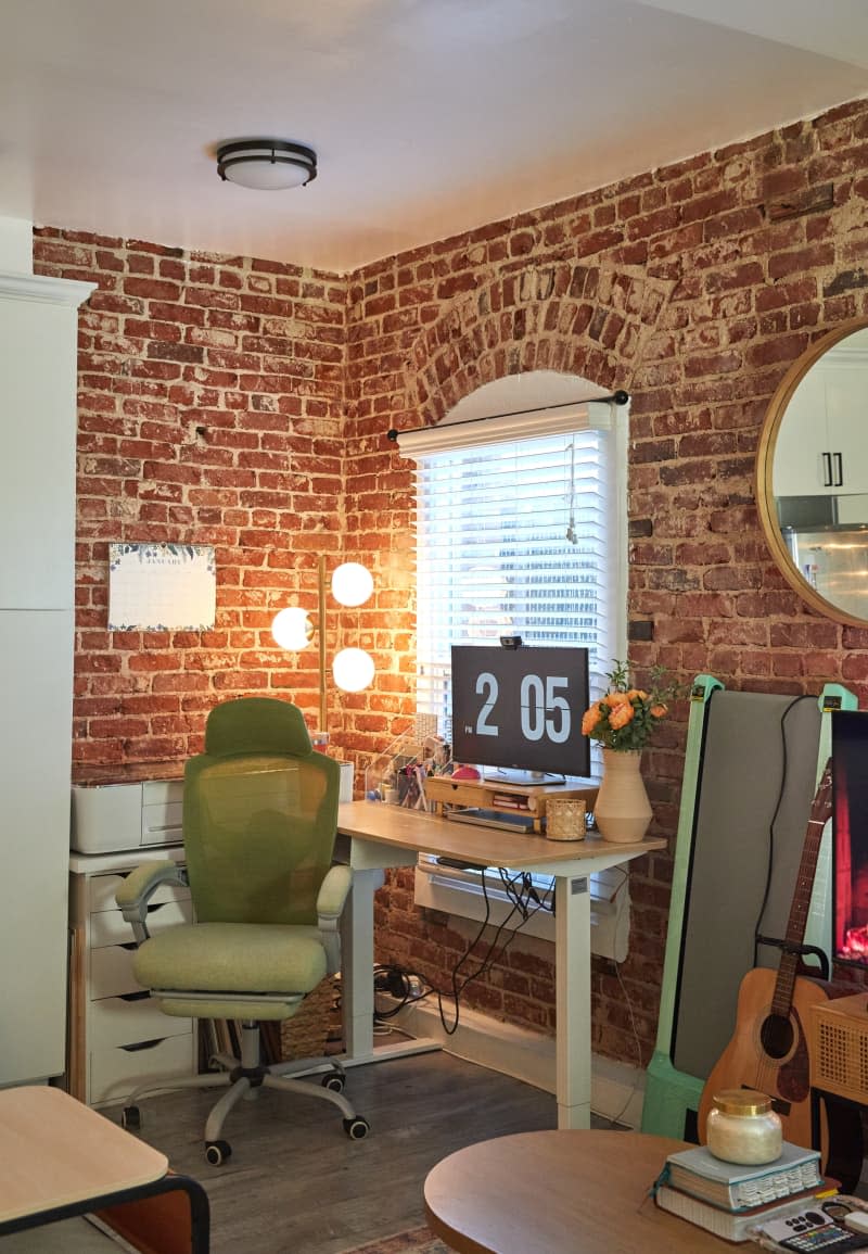 A green chair next to a standing desk.