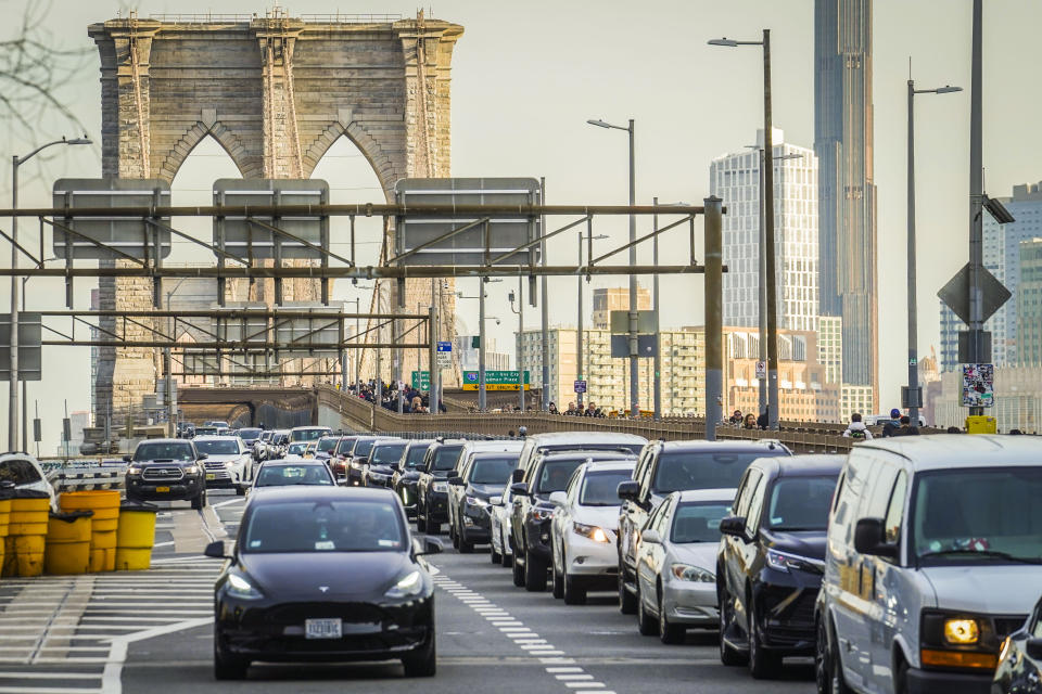 FILE - Traffic enters lower Manhattan after crossing the Brooklyn Bridge, Feb. 8, 2024, in New York. The Biden administration this week is expected to announce new automobile emissions standards that relax proposed limits in the next few years but reach the same strict standards outlined by the Environmental Protection Agency last year. (AP Photo/Bebeto Matthews, File)