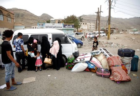 Displaced people from Hodeidah city stand next to their belongings near a school where displaced people live, in Sanaa, Yemen June 21, 2018.REUTERS/Mohamed al-Sayaghi