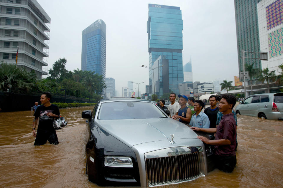 A Rolls Royce is stranded in floodwater in Jakarta's central business district on January 17, 2013 in Jakarta, Indonesia. Thousands of Indonesians were displaced and the capital was covered in many key areas in over a meter of water after days of heavy rain. (Photo by Ed Wray/Getty Images)