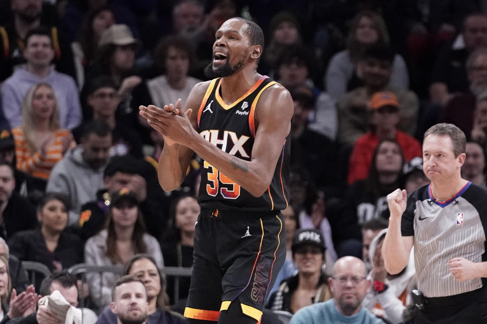 Phoenix Suns' Kevin Durant, left, applauds after being fouled by the Utah Jazz during the first half of an NBA basketball game in Phoenix, Thursday, Jan. 8, 2024. (AP Photo/Darryl Webb)