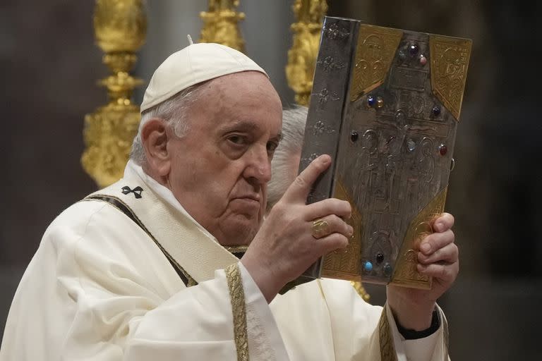 El papa Francisco muestra el Evangelio durante una misa en la basílica de San Pedro, en el Vaticano, el 14 de abril de 2022. (AP Foto/Gregorio Borgia)