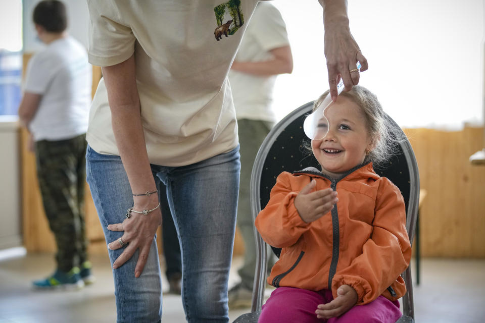 A child smiles during an eyesight examination performed by volunteer ophthalmologists, in Nucsoara, Romania, Saturday, May 29, 2021. (AP Photo/Vadim Ghirda)