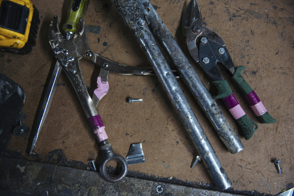 Tools used by sheet metal worker Carey Mercer to assemble ductwork are laid out on the floor of Contractors Sheet Metal on Tuesday, Aug. 3, 2021, in New York. The construction industry is fighting to recruit more women into a sector that faces chronic labor shortages. Women make up only 4% of skilled construction laborers in the U.S. and often face discrimination on jobs sites. (AP Photo/Kevin Hagen)