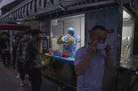 A man masks himself after getting a nuclei test for COVID-19 in Beijing Saturday, Sept. 18, 2021. China's "zero tolerance" strategy of trying to isolate every case and stop transmission of the coronavirus has kept kept the country where the virus first was detected in late 2019 largely free of the disease. (AP Photo/Ng Han Guan)