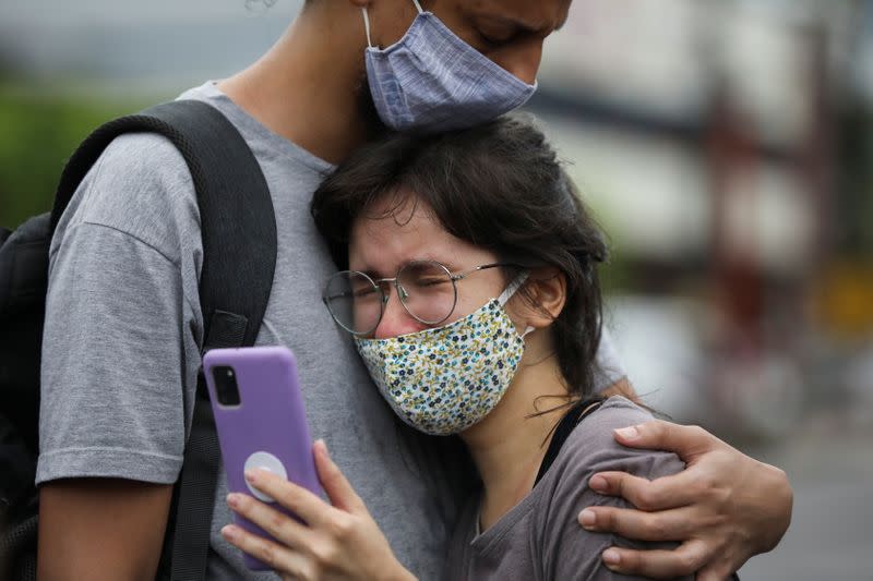 Vitor Cabral consuela a su esposa Raissa Floriano luego de que su padre es hospitalizado con COVID-19, durante una manifestación de los familiares de pacientes frente al hospital 28 de Agosto, en medio del brote de la enfermedad coronavirus (COVID-19) en Manaos, Brasil.